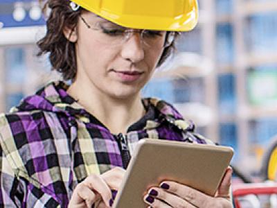 Photo of female technician taking notes in an industrial control room